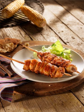 pouletspiessli-grilliert-auf-teller-mais-auf-grill